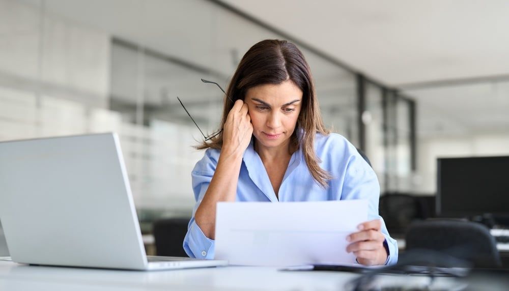 Insurance professional reviewing policy documents, representing the challenges of outsourced policy review